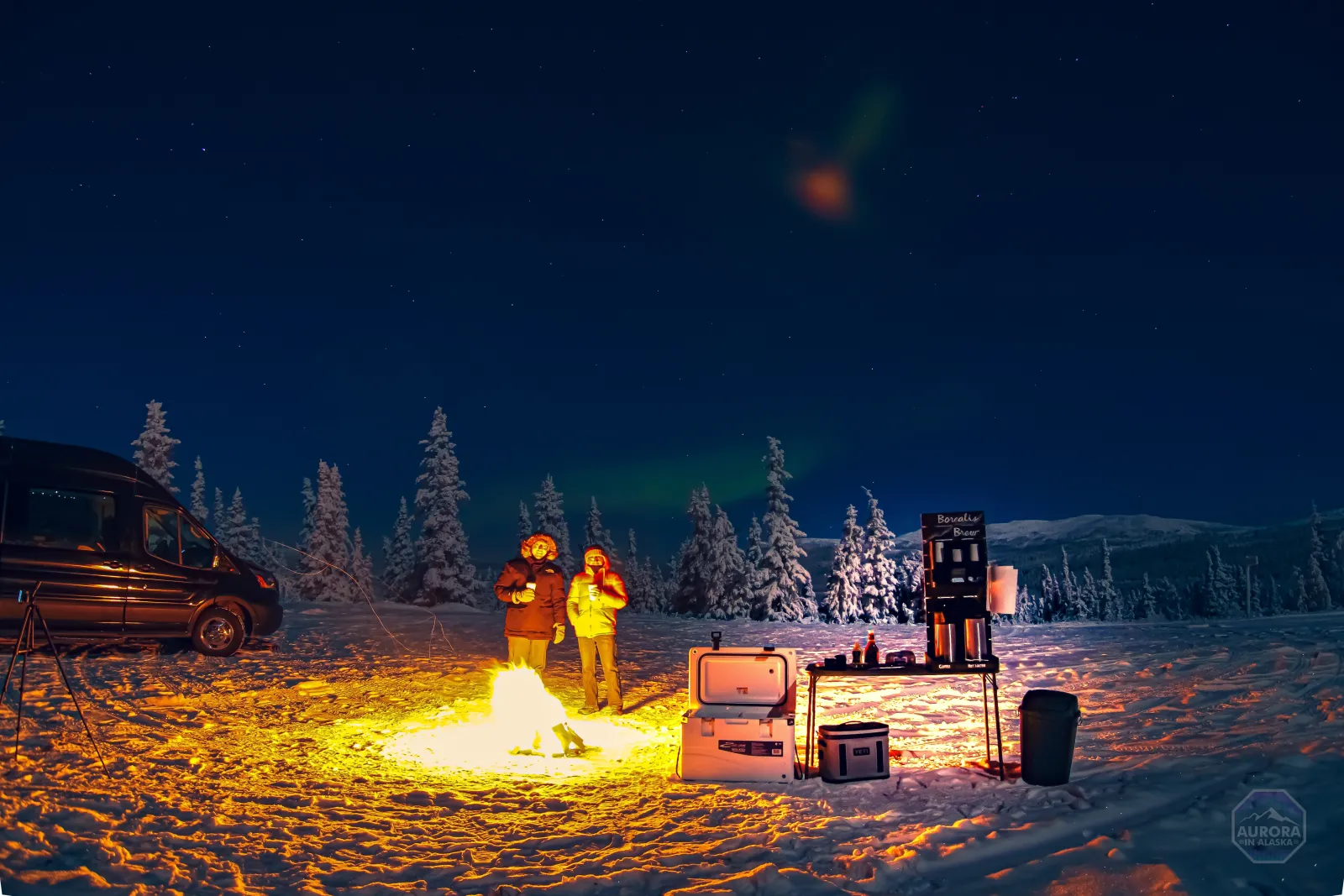 Guests warming up by a campfire beside a SkyChase van under a starry sky.